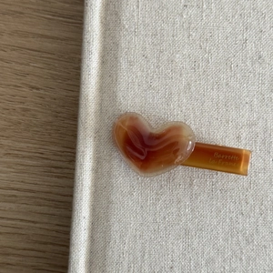 Detail of heart-shaped amber acetate hair clip with Barrette La France gold engraving