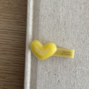 Close-up of yellow heart-shaped acetate hair clip with Barrette La France gold lettering