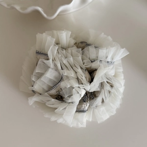 Détail d'un chouchou bohème en dentelle avec imprimé floral bleu et maille superposée
