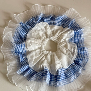 Détail du chouchou à triple couche avec motif à carreaux bleus et broderie en dentelle