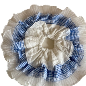 Chouchou à carreaux bleus avec dentelle blanche et tulle plissé sur fond neutre