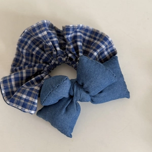 Λεπτομερής προβολή τζιν μπλε καρό scrunchie με γεμιστό φιόγκο και μικτή υφή υφάσματος