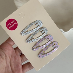 Set of 4 blue and purple star pattern BB hair clips shown on a display card