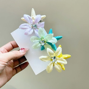 Tre fermagli per capelli con fiori e stelle marine in viola, verde e giallo con strass