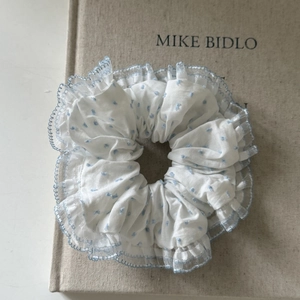 Elegant white scrunchie with light blue polka dots and delicate lace trim for hair styling
