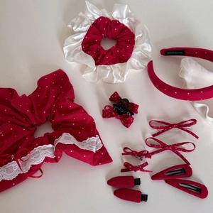 Détail d'un ensemble d'accessoires à pois rouges et blancs avec chouchous et nœuds