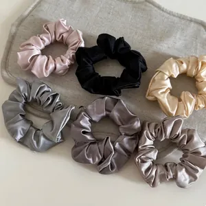 6-piece set of silky satin scrunchies in neutral tones on a gray linen background