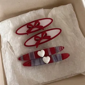 French red acetate hair clips set featuring heart and bow designs in a gift box