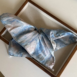 Detailaufnahme des sternenblauen Seiden-Scrunchies mit Tintendruck und weißen Perlen