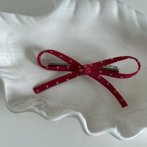 Détail d'un nœud papillon rouge à pois avec pince en métal sur plateau