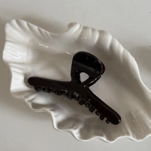 Pince à cheveux noire brillante au design croisé pour coiffures élégantes à la française