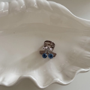French vintage mini cherry hair claw with blue rhinestones on a white shell plate