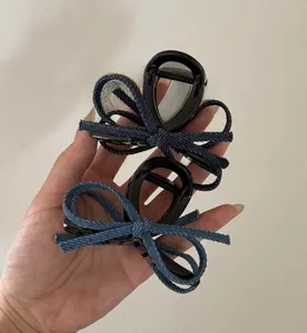 Detail of denim fabric bow hair claws in light and dark blue with black polished clips