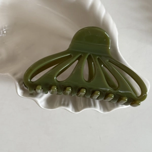 Elegante pinza per capelli verde oliva a forma di ventaglio in un piatto a conchiglia