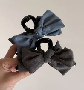 Detailed view of large denim bow hair claw clips with subtle sparkling sequins