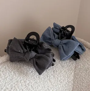 Detailed view of denim bow hair claws in dark grey and blue with subtle sequins