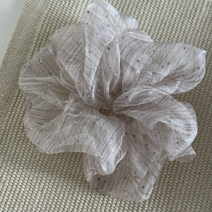 Elegant champagne seersucker scrunchie with silver rhinestones on a textured knit background