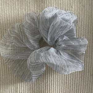 Macro detail of silver bubble gauze scrunchie with black stripes and sparkling rhinestones
