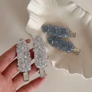 Exquisite crystal rhinestone hair clips in light blue and silver on a decorative plate
