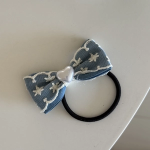 Detail van blauwe kant haardecoratie met sterborduurwerk en een hartjeskraal
