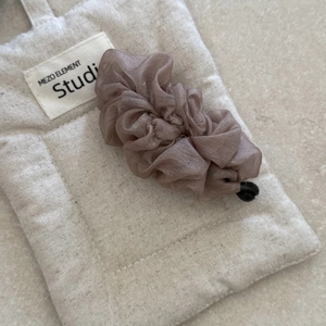 Close-up of chiffon pleated banana clip showing fabric texture and functional drawstring buckle