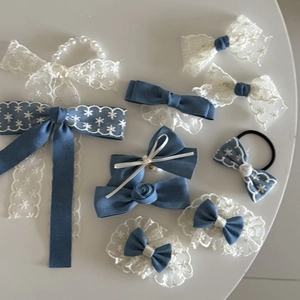 Detailed macro of French lace hair clips with delicate blue floral embroidery and pearls