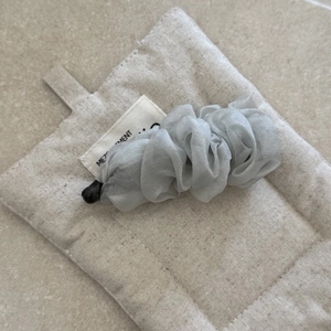 Close-up of pleated chiffon fabric texture on grey banana hair clip for women