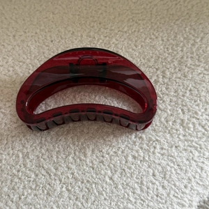 Macro detail of wine red translucent resin hair claw clip with crescent moon silhouette