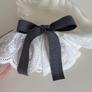 Elegant French lace hair clip with a dark grey plaid bow on a white shell tray