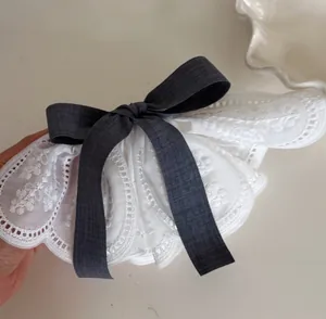 Close-up of elegant French lace hair clip with a vintage dark grey fabric bow detail