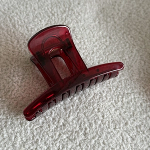 Close-up of a deep red transparent acrylic shark hair claw clip with glossy finish