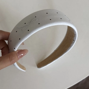 Polka dot wide headband with white base, black dots and side bow embroidery detail