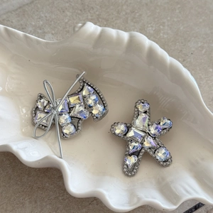 Elegant rhinestone dog and star hair clips set with sparkling crystals on white dish