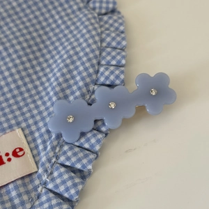 Nahaufnahme der blauen Acryl-Blumen-Haarspange mit funkelnden Strasssteinen