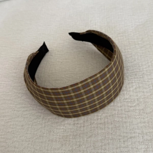 Gros plan du serre-tête écossais marron vintage avec tissu tissé et doublure antidérapante