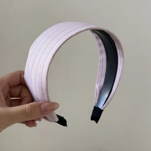 Détail du serre-tête rose à pois montrant la texture du tissu et les dents antidérapantes