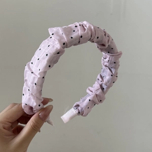 Vue détaillée du serre-tête rose à pois avec texture plissée et rembourrage moelleux