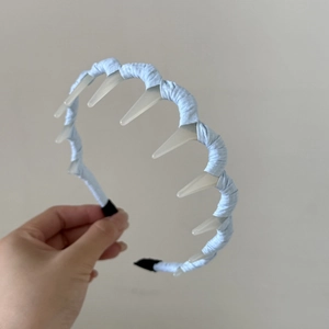Détail du serre-tête à carreaux bleu clair montrant les dents blanches et la texture