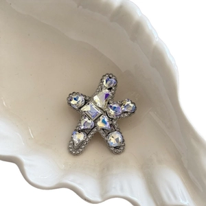Sparkling starfish hair clip with AB crystals and rhinestones on a ceramic shell plate