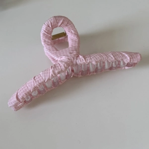 Détail de la pince à cheveux en tissu à carreaux roses avec ressort en métal doré