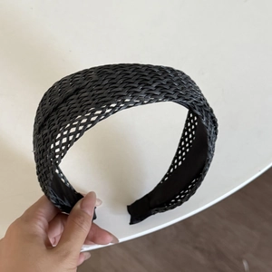 Detail of black woven wide headband showing textured cross-braid and non-slip inner lining