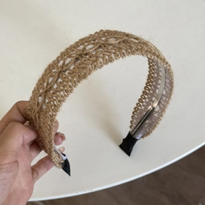 Close-up of bohemian earth-tone crochet headband with scalloped edges and woven texture