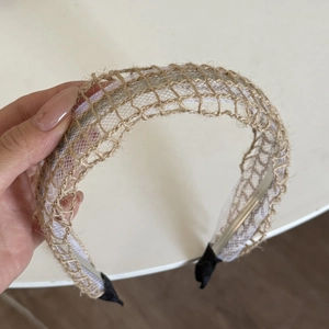 Close-up of bohemian woven straw headband with brown lattice pattern and mesh lining
