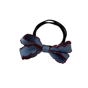 Sky blue denim bow hair tie with red scalloped edges and elastic black hair band