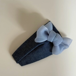Detailansicht der Haarspange aus Denim-Stoff mit einer hellblauen Chiffon-Schleife