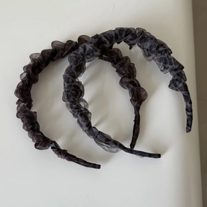 Detail of leopard print pleated organza headband with internal plastic comb teeth