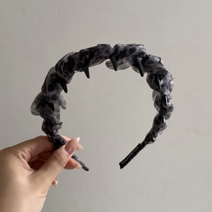 Detailed view of handmade leopard print headband with punk rivet studs and pleated fabric