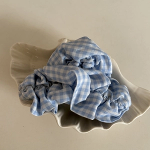 Minimalist blue gingham check oversized hair scrunchie displayed on a shell tray