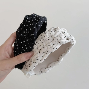 Detail of two woven polka dot headbands in black and white French style mesh