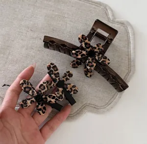 Detail of leopard print flower hair clip set featuring coffee and black claw clips